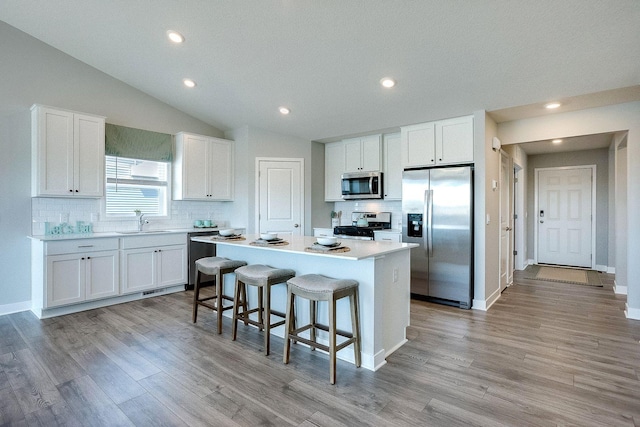 13540 Carrakay Way, Rosemount, MN 55068 - kitchen featuring appliances with stainless steel finishes, a sink, decorative backsplash, a kitchen island, and recessed lighting