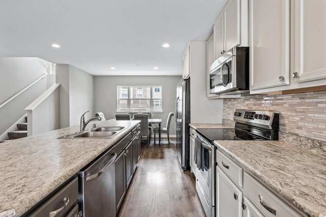 7363 146th Xing NW, Ramsey, MN 55303 - kitchen featuring stainless steel appliances, dark wood-type flooring, white cabinets, light countertops, and tasteful backsplash