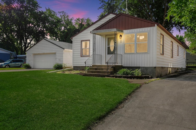 111 4th St, Kenyon, MN 55946 - view of front of house with a yard, a detached garage, board and batten siding, and an outdoor structure