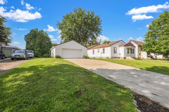 111 4th St, Kenyon, MN 55946 - view of front of home with an outdoor structure, a detached garage, and a front yard