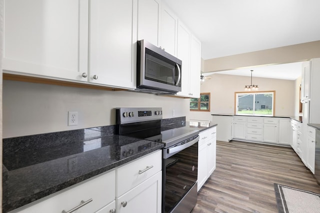 111 4th St, Kenyon, MN 55946 - kitchen with stainless steel appliances, wood finished floors, white cabinets, dark stone counters, and decorative light fixtures