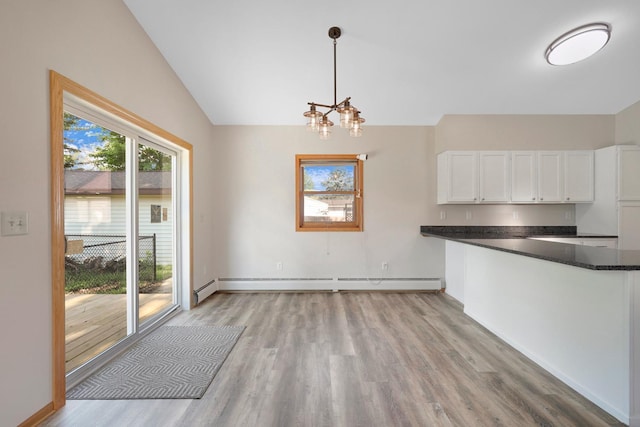 111 4th St, Kenyon, MN 55946 - unfurnished dining area featuring a baseboard radiator, vaulted ceiling, light wood-type flooring, a chandelier, and baseboards