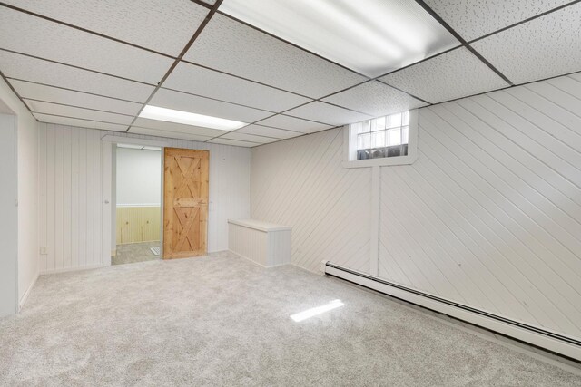 111 4th St, Kenyon, MN 55946 - below grade area with a baseboard radiator, a paneled ceiling, carpet floors, and wood walls