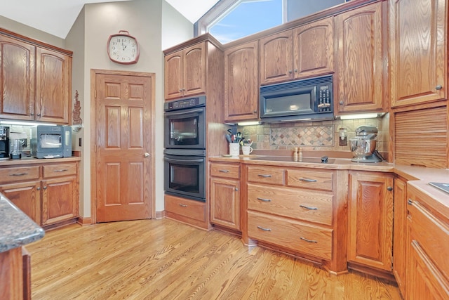 13023 Yellow Pine Cir NW, Coon Rapids, MN 55448 - kitchen with black appliances, decorative backsplash, light wood-style floors, lofted ceiling, and light countertops