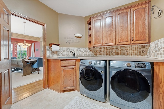 13023 Yellow Pine Cir NW, Coon Rapids, MN 55448 - laundry room featuring a chandelier, washer and dryer, cabinet space, and light flooring