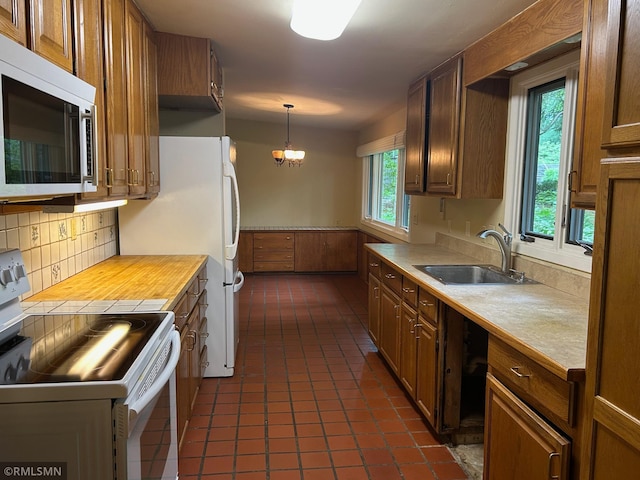 11209 Oak Ridge Ln W, Minnetonka, MN 55305 - kitchen featuring white appliances, light countertops, dark tile patterned floors, decorative backsplash, and decorative light fixtures