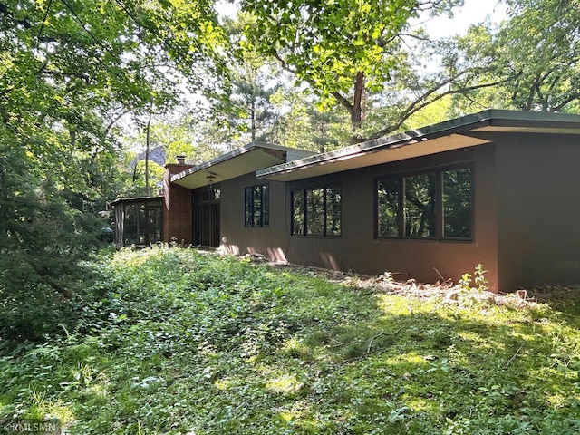 11209 Oak Ridge Ln W, Minnetonka, MN 55305 - view of property exterior with a chimney and stucco siding