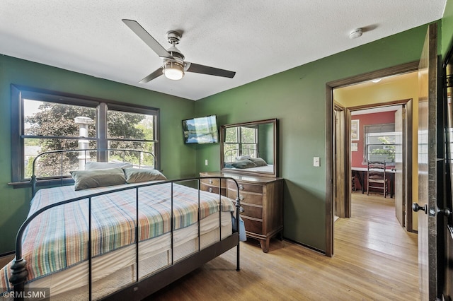 6316 15th Ave S, Richfield, MN 55423 - bedroom with light wood-type flooring, a textured ceiling, and a ceiling fan