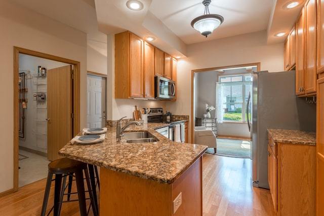 2230 Lower Afton Rd E, Saint Paul, MN 55119 - kitchen with stainless steel appliances, a sink, a peninsula, light wood-style floors, and dark stone countertops