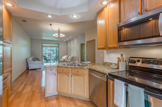2230 Lower Afton Rd E, Saint Paul, MN 55119 - kitchen with stainless steel appliances, a peninsula, a sink, light wood-style flooring, and a chandelier