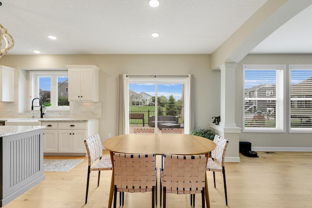8633 Ambergate Dr, Victoria, MN 55386 - dining space with light wood-style flooring, ornate columns, and recessed lighting