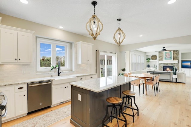 8633 Ambergate Dr, Victoria, MN 55386 - kitchen with dishwasher, plenty of natural light, a ceiling fan, a stone fireplace, and recessed lighting