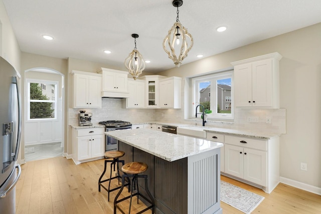 8633 Ambergate Dr, Victoria, MN 55386 - kitchen with appliances with stainless steel finishes, under cabinet range hood, light wood-type flooring, backsplash, and recessed lighting
