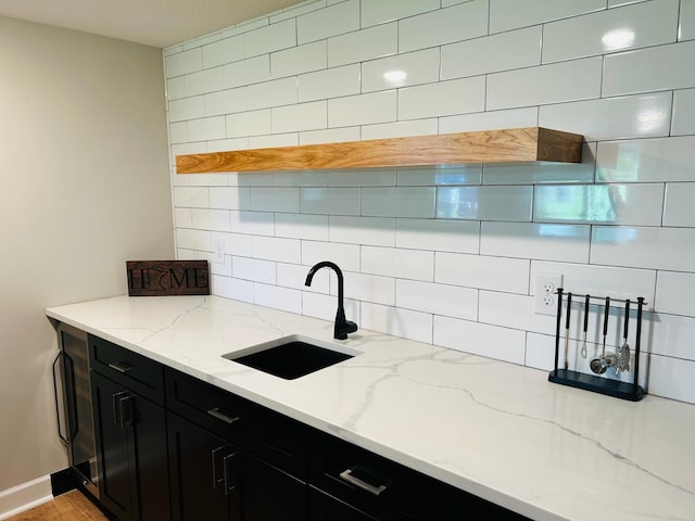 8633 Ambergate Dr, Victoria, MN 55386 - kitchen featuring dark cabinets, decorative backsplash, and light stone counters