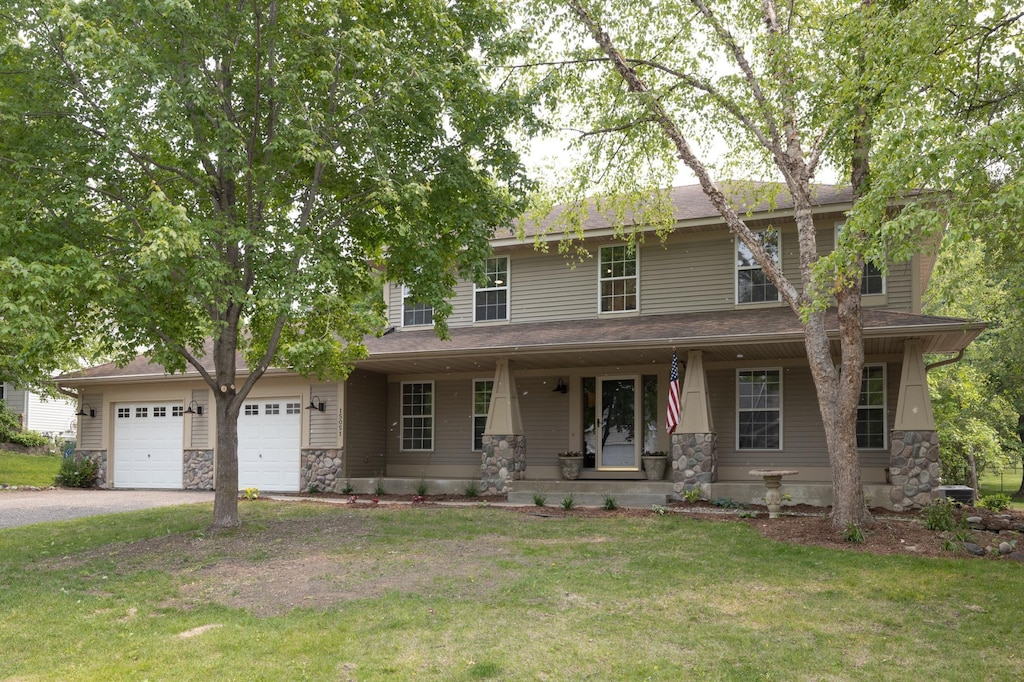 15051 Black Oak Rd NE, Prior Lake, MN 55372 - view of front of property with stone siding, asphalt driveway, a porch, a front lawn, and a garage