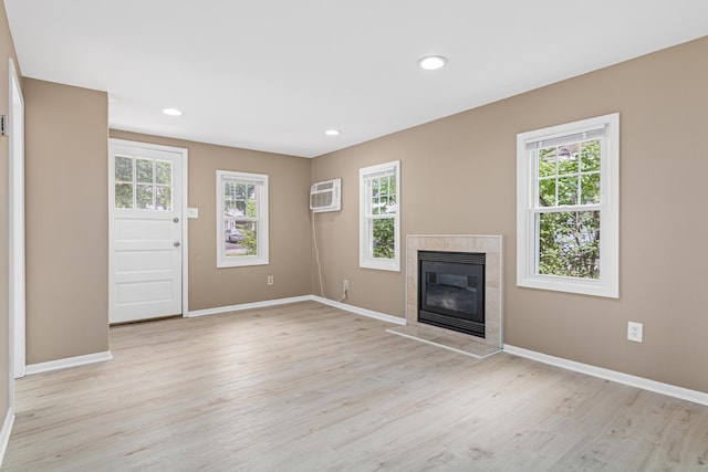 753 8th Ave S, Hopkins, MN 55343 - unfurnished living room with a tiled fireplace, a wall mounted air conditioner, light wood-style floors, baseboards, and recessed lighting