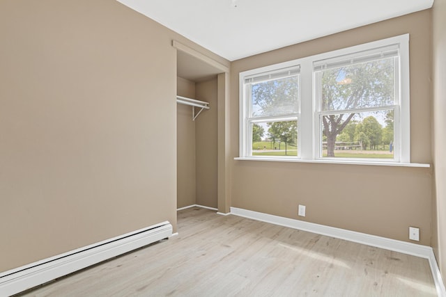 753 8th Ave S, Hopkins, MN 55343 - unfurnished bedroom with a baseboard heating unit, light wood-style flooring, baseboards, and a closet