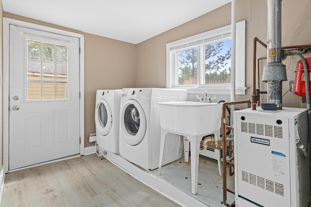 753 8th Ave S, Hopkins, MN 55343 - laundry room with healthy amount of natural light, light wood-style flooring, washer and clothes dryer, and a heating unit