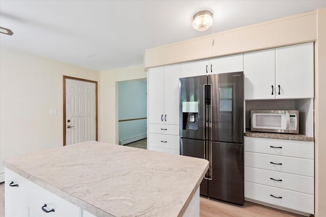 41502 Flink Ave, North Branch, MN 55056 - kitchen featuring stainless steel fridge, white microwave, a baseboard heating unit, light wood-style floors, and light countertops
