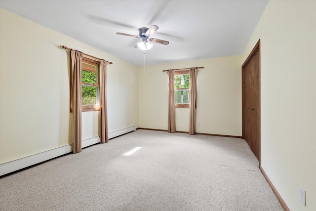 41502 Flink Ave, North Branch, MN 55056 - unfurnished bedroom featuring light colored carpet, baseboard heating, and a ceiling fan