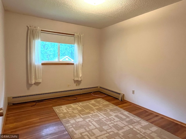 1277 Shakopee Ave E, Shakopee, MN 55379 - empty room featuring wood finished floors, a textured ceiling, a baseboard heating unit, and baseboards