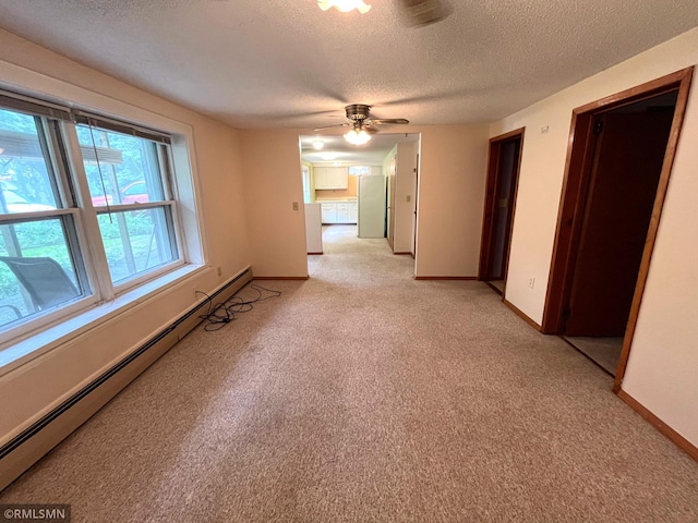 1277 Shakopee Ave E, Shakopee, MN 55379 - spare room featuring a textured ceiling, light colored carpet, baseboard heating, a ceiling fan, and baseboards