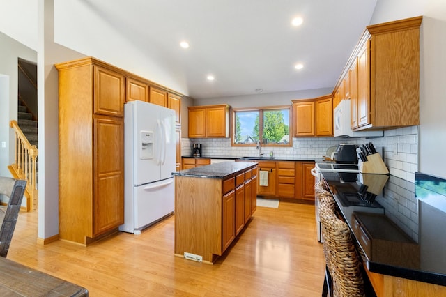6445 Coryell Ct, Inver Grove Heights, MN 55076 - kitchen featuring white appliances, tasteful backsplash, a center island, light wood-style flooring, and brown cabinets