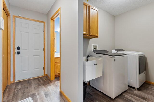 6445 Coryell Ct, Inver Grove Heights, MN 55076 - laundry room featuring cabinet space, a textured ceiling, dark wood-type flooring, and washing machine and clothes dryer