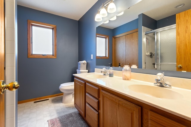 6445 Coryell Ct, Inver Grove Heights, MN 55076 - full bathroom featuring double vanity, a stall shower, tile patterned floors, toilet, and baseboards