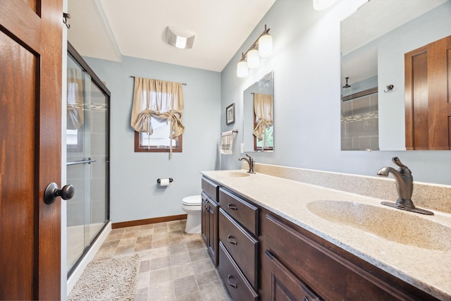 231 Winkler Trl, Cologne, MN 55322 - bathroom featuring a tile shower, toilet, double vanity, and baseboards