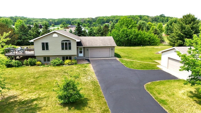 881 217th St, Osceola, WI 54020 - split level home featuring a front yard, a deck, a wooded view, a garage, and driveway