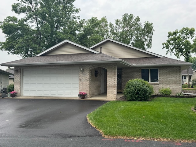 325 Waite Ave S, Saint Cloud, MN 56301 - view of front of house with an attached garage, roof with shingles, driveway, brick siding, and a front yard
