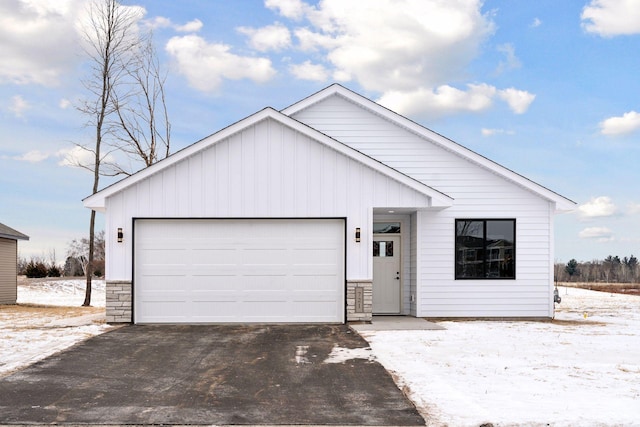 631 7th Ave NE, Isanti, MN 55040 - view of front facade featuring a garage, board and batten siding, and driveway