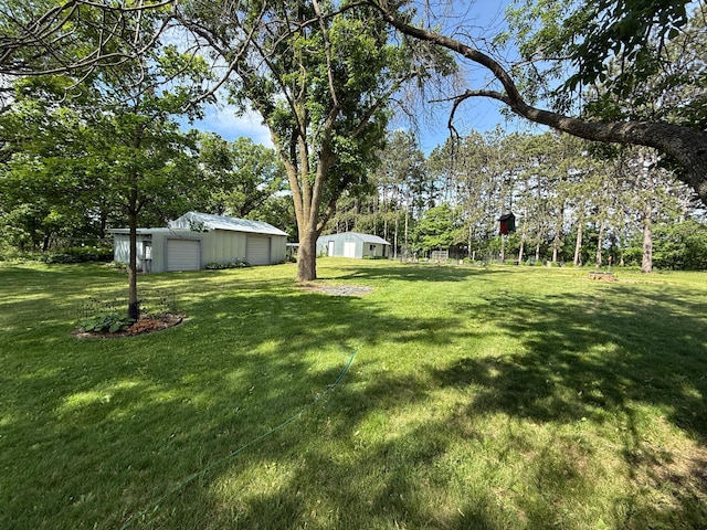 26813 Scenic Byway Rd, Faxon Twp, MN 56011 - view of green lawn with a garage, an outdoor structure, and view of scattered trees