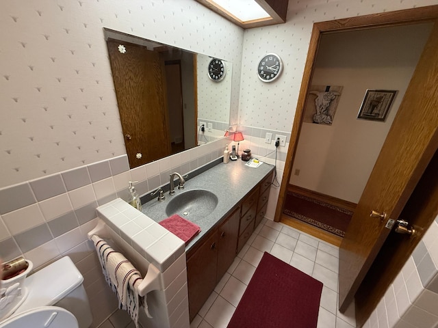 26813 Scenic Byway Rd, Faxon Twp, MN 56011 - bathroom featuring wallpapered walls, vanity, toilet, tile patterned flooring, and a wainscoted wall