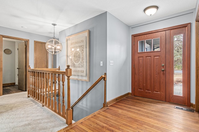 6230 Elm Ridge Cir, Corcoran, MN 55340 - foyer entrance featuring light wood-style flooring, baseboards, and a chandelier