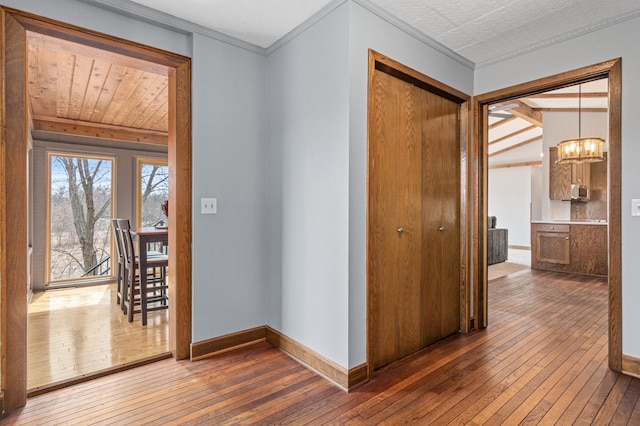 6230 Elm Ridge Cir, Corcoran, MN 55340 - hall with hardwood / wood-style floors, a chandelier, ornamental molding, and baseboards