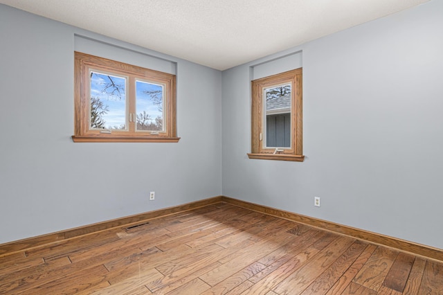 6230 Elm Ridge Cir, Corcoran, MN 55340 - empty room with wood-type flooring, baseboards, and a textured ceiling