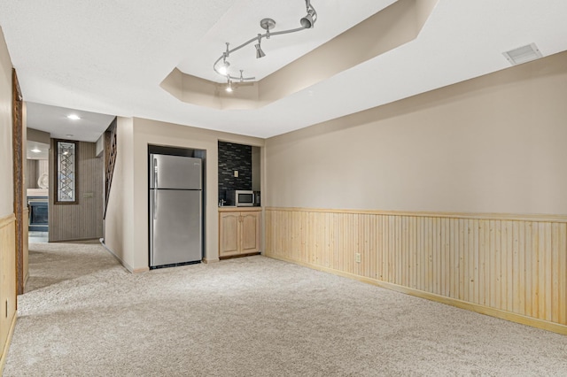 6230 Elm Ridge Cir, Corcoran, MN 55340 - empty room featuring light colored carpet, a wainscoted wall, wooden walls, and a raised ceiling