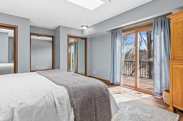 6230 Elm Ridge Cir, Corcoran, MN 55340 - bedroom with access to exterior, a skylight, light wood-style flooring, and baseboards
