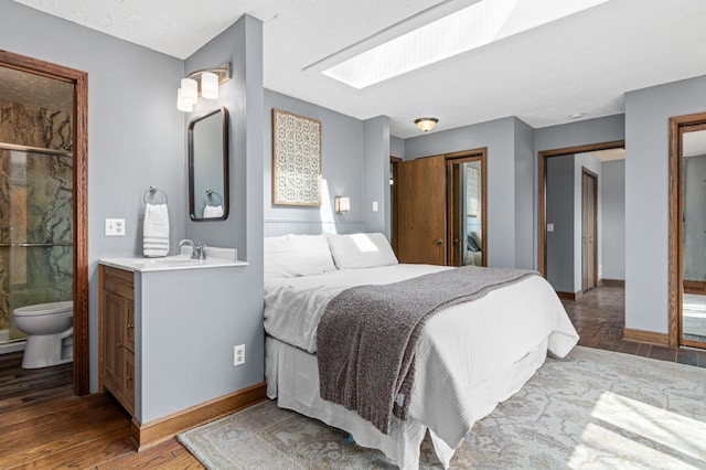6230 Elm Ridge Cir, Corcoran, MN 55340 - bedroom with wood-type flooring, baseboards, ensuite bathroom, and a sink