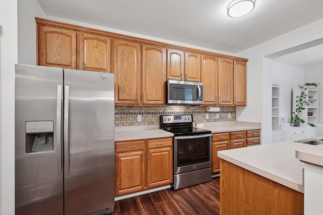 1924 Shamrock Pl, Chaska, MN 55318 - kitchen with appliances with stainless steel finishes, dark wood-style floors, light countertops, decorative backsplash, and brown cabinetry