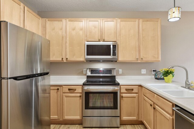 17829 66th Ave N, Maple Grove, MN 55311 - kitchen featuring appliances with stainless steel finishes, light brown cabinets, light countertops, a textured ceiling, and hanging light fixtures
