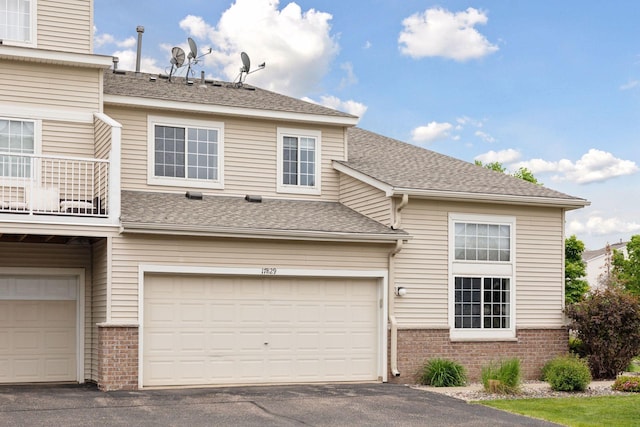 17829 66th Ave N, Maple Grove, MN 55311 - view of front of house with brick siding, asphalt driveway, a balcony, an attached garage, and roof with shingles