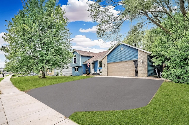 1439 Oakdale Ave W, Saint Paul, MN 55118 - view of front of house featuring driveway, a garage, brick siding, and a front yard