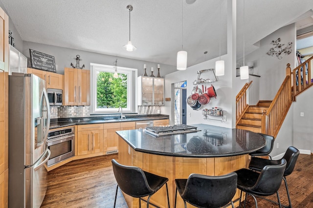 1439 Oakdale Ave W, Saint Paul, MN 55118 - kitchen featuring appliances with stainless steel finishes, a sink, dark wood finished floors, a breakfast bar, and a textured ceiling