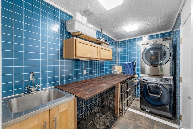 1439 Oakdale Ave W, Saint Paul, MN 55118 - washroom featuring stacked washer / drying machine, tile walls, and dark tile patterned floors