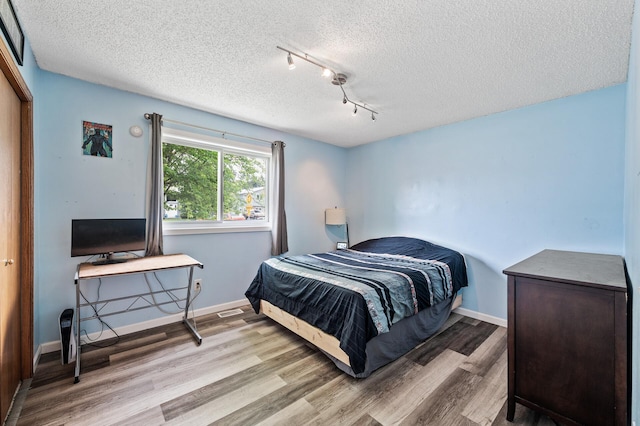 1439 Oakdale Ave W, Saint Paul, MN 55118 - bedroom with wood finished floors, a textured ceiling, track lighting, and baseboards