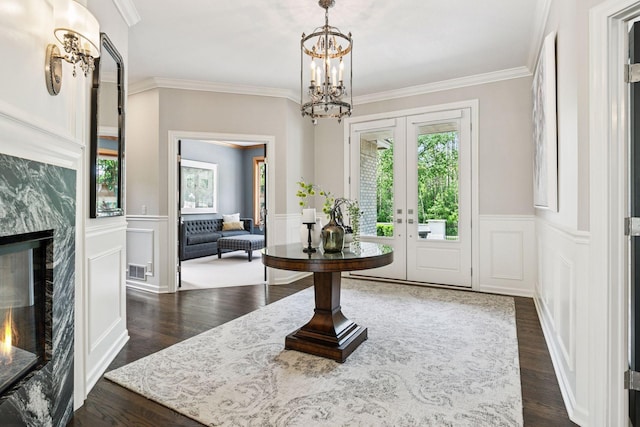 9320 Abigail Ct, Inver Grove Heights, MN 55077 - foyer featuring a premium fireplace, a chandelier, ornamental molding, dark wood-style flooring, and a wainscoted wall