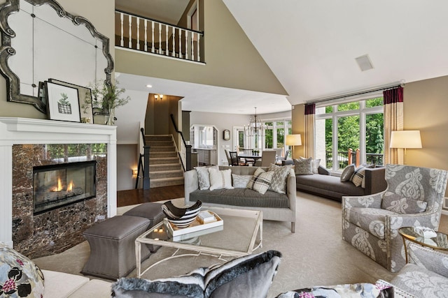 9320 Abigail Ct, Inver Grove Heights, MN 55077 - living room featuring stairs, high vaulted ceiling, a fireplace, a chandelier, and carpet flooring